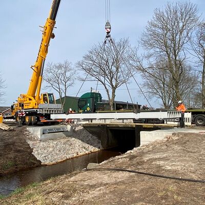 Neues Brückenteil wird mit einem Kran über den Fluss gesetzt.