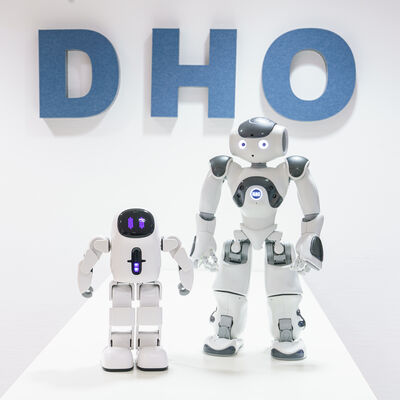 zwei Roboter vor dem Logo des Digital Hub Ostfriesland