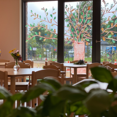 Ansicht auf Gruppentische vor einer Fensterfront