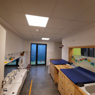 Wickeltische rechts und kleine Waschbecken an der linken Wand