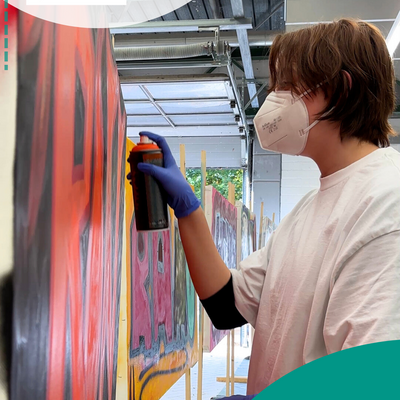 Junge spr&uuml;ht Wand an