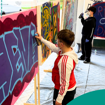 Junge spr&uuml;ht Wand an