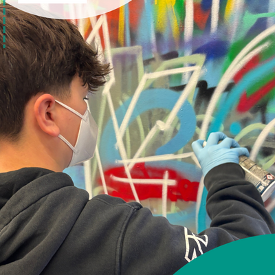 Junge spr&uuml;ht Wand an