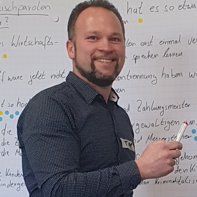Tim Tjettmers vor einem Whiteboard mit einem Stift in der Hand
