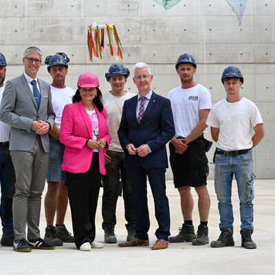 Bauarbeiter, Bundestagsabgeordnete Gitta Connemann, B&uuml;rgermeister Heiko Abbas (2 von links) und Landrat Matthias Groote (6. von links) unterm Richtkranz.